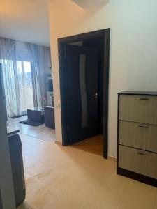 a room with a black door and a wooden dresser at Apartament Karina in Dudu +3 photos