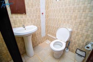 a bathroom with a toilet and a sink at Tulivu Home in Ruaka
