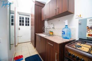 a kitchen with a sink and a bottle of water on the counter at Tulivu Home in Ruaka