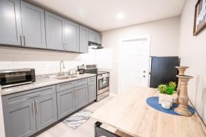 a kitchen with gray cabinets and a wooden table at University Luxe Residences in Tampa +12 photos