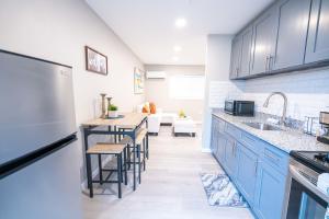a kitchen with blue cabinets and a table with stools at University Luxe Residences in Tampa