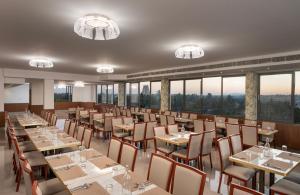 una sala da pranzo con tavoli, sedie e finestre di Hotel Sri Ashvik Rameswaram a Rāmeswaram