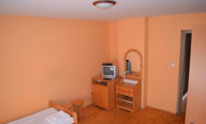 ein Schlafzimmer mit einem Bett und einem TV auf einer Kommode in der Unterkunft Villa Silver Green in Žarnovica