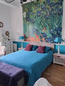 a bedroom with a blue bed with a painting on the wall at Appartement 4* en résidence privée in Châtel-Guyon