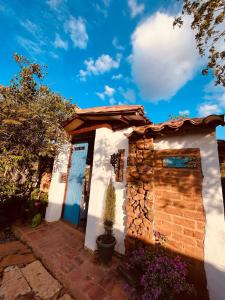 a small white house with a blue door at Villa Paula in Barichara