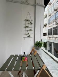 a green table in a room with a white wall at Mosaikon Guesthouses #Kolokotroni Str in Athens