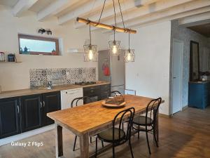a kitchen with a wooden table and chairs at Chez yoan et laurie in Corbelin +9 photos