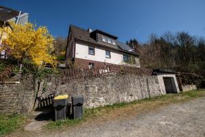 a house sitting on top of a stone wall at Schöne Ferienwohnung in ruhiger Lage in Altena