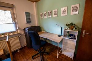 an office with a desk and a chair and a window at Schöne Ferienwohnung in ruhiger Lage in Altena
