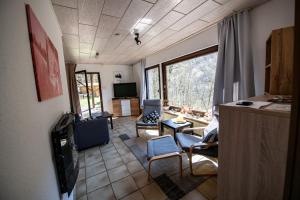 a living room with chairs and a couch and a tv at Schöne Ferienwohnung in ruhiger Lage in Altena