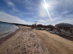 a beach with umbrellas and chairs and the ocean at princess Resort Hurghada in Hurghada