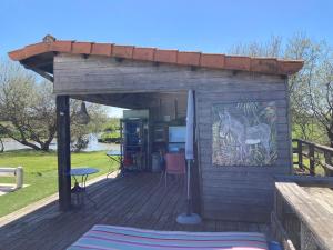 a wooden deck with a building with a painting of a horse at Au cœur du marais breton in Bois-de-Cené