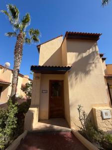 Un pequeño edificio blanco con una palmera. en Casa Amore, en Parque Holandes