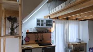 a kitchen with white cabinets and a table in a room at Fresh romance by the river in Bohinj