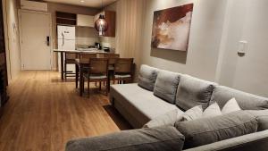 Una sala de estar con un sofá y un comedor. en Esplendor Flat no Serra Class, en Canela