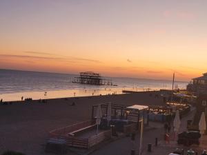 a view of a beach with a pier at sunset at Atlantic Seafront in Brighton & Hove