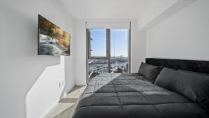 a living room with a black couch and a window at 2-Bedr Downtown Miami Condo Bay Views in Miami