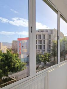 a window with a view of a building at Casa Bela in Mindelo +61 photos