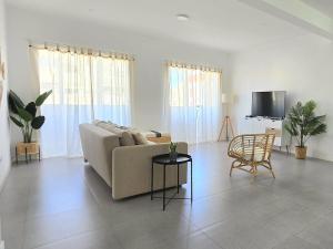 a living room with a couch and a table and a tv at Casa Bela in Mindelo