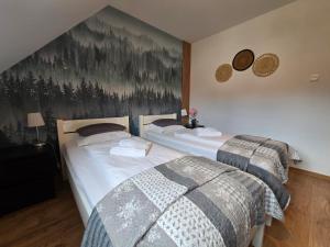 two beds in a bedroom with a painting on the wall at Domek 4Seasons Karpacz z prywtną Sauną i Kominkiem in Karpacz