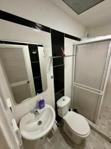 a bathroom with a white toilet and a sink at Apartamento en el centro de Tuluá in Tuluá