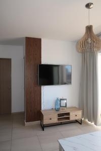 Una sala de estar con un televisor de pantalla plana en una pared. en apartment 5 minutes from the beach, en Mazatlán