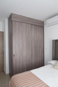 1 dormitorio con un gran cabecero de madera junto a una cama en apartment 5 minutes from the beach, en Mazatlán 15 fotos más