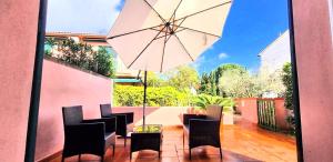 a patio with chairs and a table with an umbrella at Casa Giardino in Marina di Campo
