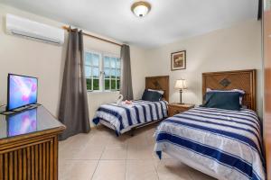 um quarto com duas camas e uma TV de tela plana em Palma Real 29 em Palm Beach