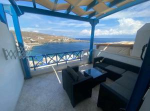 a balcony with a couch and a view of the ocean at Fantastic View Suite Kythnos in Kithnos