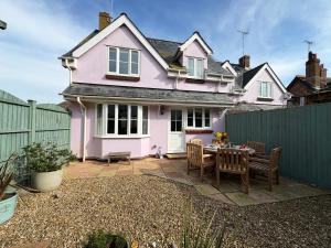 a pink house with a table and chairs at Seagull Cottage in Lyme Regis