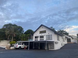 a white house with a car parked in front of it at Dwengu Guest house in Margate