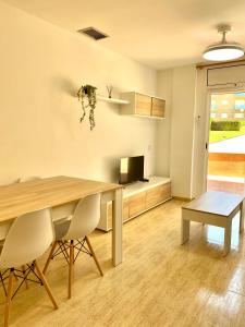 a dining room with a table and a television at Frente al mar con piscina para 4 in L'Ampolla +22 photos
