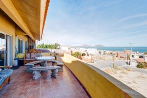 - un balcon avec une table et des bancs donnant sur l'océan dans l'établissement Beach Condo 7-- Sleeps 8, Pool, WiFi, AC, Security, à San Felipe