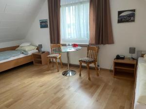 una stanza con un tavolo, due sedie e un letto di Hotel Restaurant Friedrichshöhe a Braunschweig Altre 4 foto