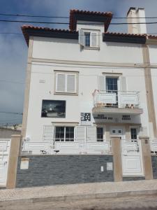 - un bâtiment blanc avec un balcon sur le côté dans l'établissement Guesthouse, Ap Veríssimo, à Nazaré