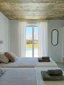 a bedroom with a large bed with a large window at Casa Fá - NEW T4 - Aljezur in Aljezur