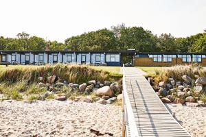 a building on the beach with a wooden bridge at Danhostel Nykøbing Mors in Nykøbing Mors