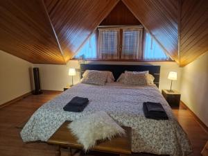 a bedroom with a large bed with a wooden ceiling at La Buhardilla de Gavin in Gavín