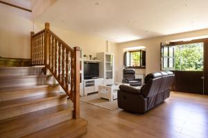 ein Wohnzimmer mit einer Treppe und einem TV in der Unterkunft La Corvera en Collera, Ribadesella in Collera
