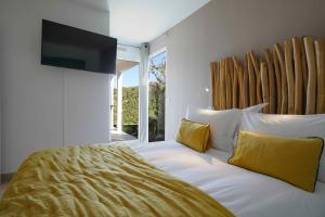 a bedroom with a large bed with yellow pillows at Pearl's Roc Villa in Gustavia
