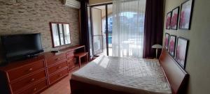 a bedroom with a large bed and a television at GL Beach Resort Private Studio Sozopol in Sozopol