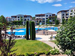 a resort with a swimming pool with people and umbrellas at GL Beach Resort Private Studio Sozopol in Sozopol
