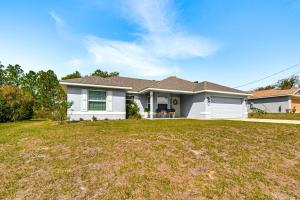 a white house with a large yard at Screened Lanai Relaxing Retreat in Ocala! in Ocala