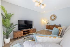 ein Wohnzimmer mit Sofa und Fernseher in der Unterkunft Casa da Ilha in Funchal