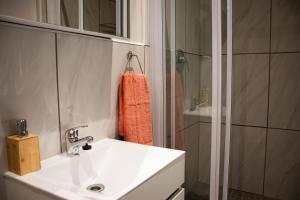 bagno con lavandino bianco e doccia di The Garden Manor a Winterton
