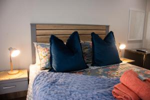 una camera da letto con un letto blu con cuscini blu di The Garden Manor a Winterton Altre 37 foto