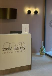 a counter with a vase sitting next to a wall at Via del Mare Apulia B&B e Spa Suites in Rutigliano