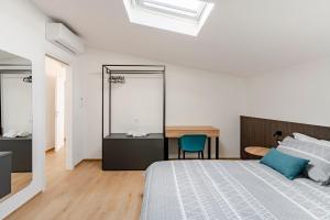 a white bedroom with a bed and a desk at Sole Luxury terrace,Central apartment in Matera
