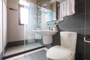 a bathroom with a toilet and a sink and a shower at Valley Silence B&B in Ji'an